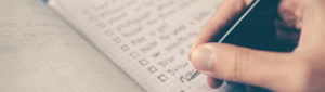 Closeup of hand holding pen making checklist
