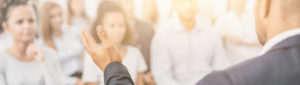 close up of a speaker delivering a speech to an attentive crowd