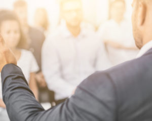 close up of a speaker delivering a speech to an attentive crowd