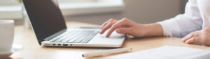 Close up of female using laptop computer to apply for a loan online