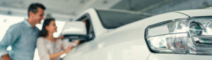 Hispanic couple car shopping and looking at luxury suv