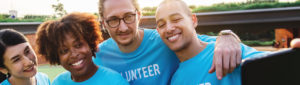 group of volunteers huddled together taking a selfie with smartphone
