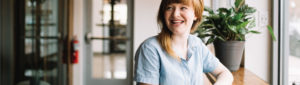 young female adult sitting in cafe and smiling